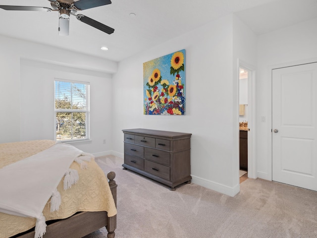 bedroom featuring light colored carpet, ceiling fan, and ensuite bathroom