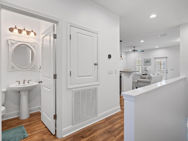 corridor featuring hardwood / wood-style flooring and sink