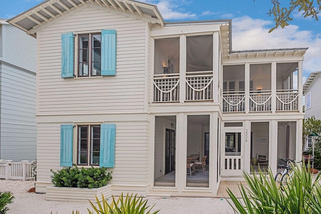 back of property with a balcony and a sunroom