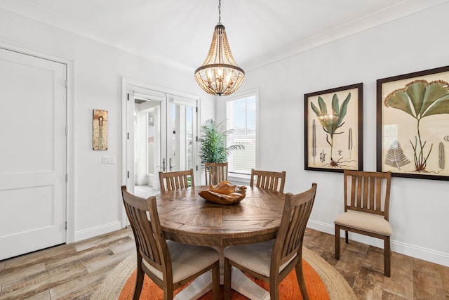 dining room featuring a notable chandelier, light hardwood / wood-style floors, and french doors