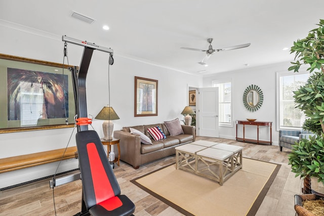 living room featuring crown molding, ceiling fan, and light hardwood / wood-style flooring