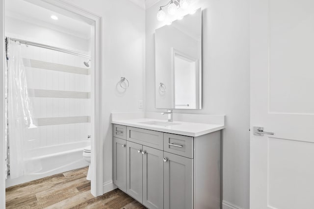 full bathroom featuring wood-type flooring, toilet, shower / bathtub combination with curtain, and vanity