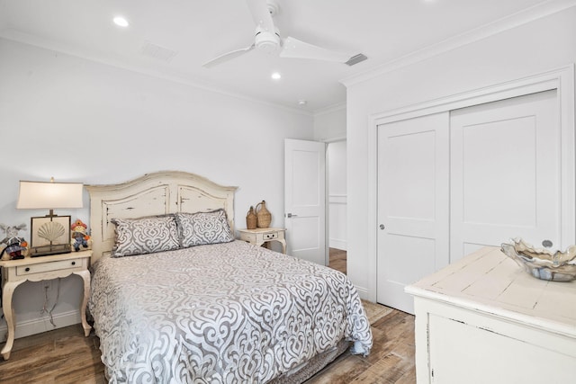 bedroom with a closet, ornamental molding, dark hardwood / wood-style floors, and ceiling fan