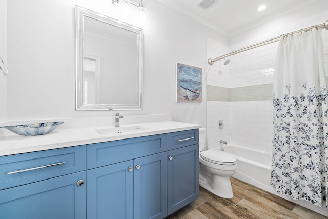 full bathroom with hardwood / wood-style flooring, vanity, shower / tub combo, and toilet