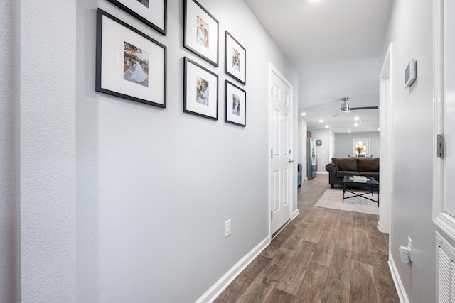 hall with dark wood-type flooring and baseboards