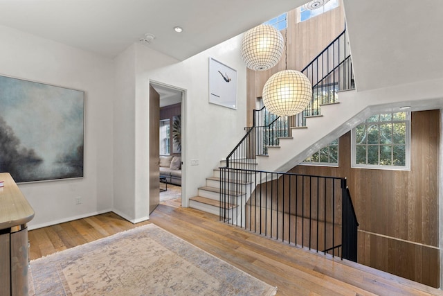 stairs featuring hardwood / wood-style flooring and an inviting chandelier