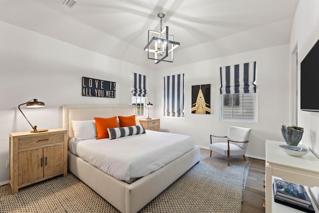 bedroom featuring wood-type flooring and a notable chandelier