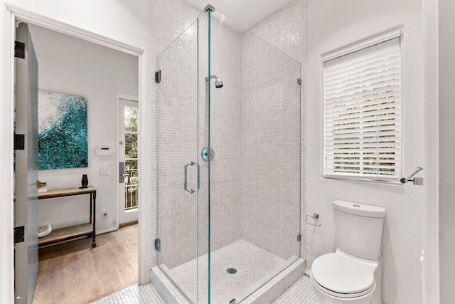 bathroom featuring hardwood / wood-style floors, toilet, and walk in shower