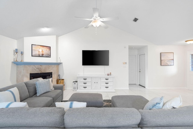 tiled living room featuring ceiling fan, a premium fireplace, and vaulted ceiling