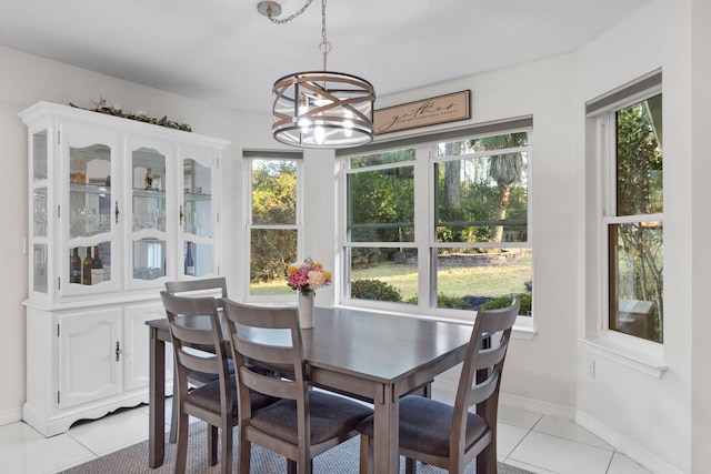 dining space featuring a notable chandelier, light tile patterned floors, and plenty of natural light