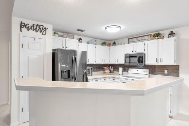 kitchen with white cabinets, stainless steel appliances, a textured ceiling, and light tile patterned floors