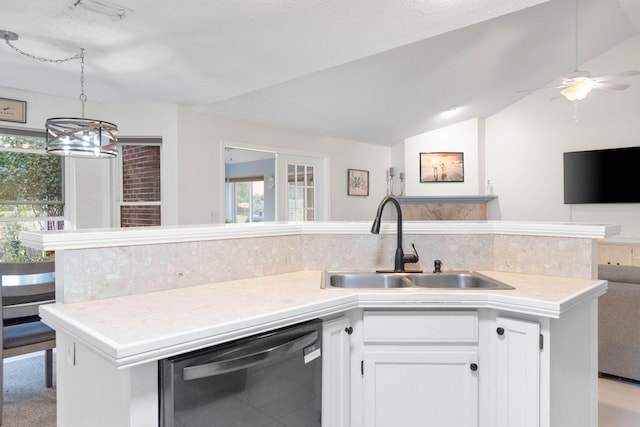 kitchen featuring sink, white cabinets, vaulted ceiling, black dishwasher, and backsplash