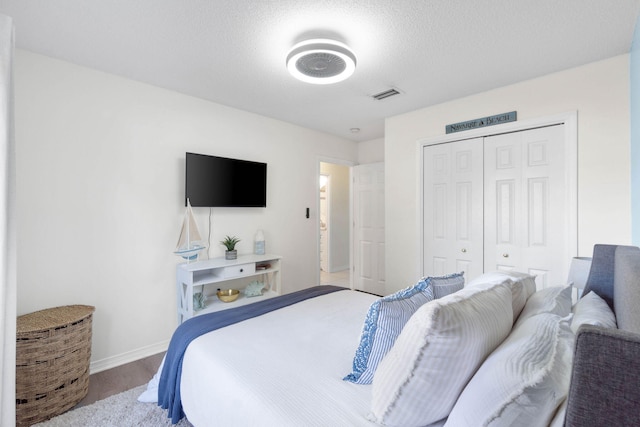 bedroom featuring a textured ceiling, a closet, and hardwood / wood-style flooring