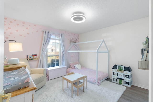 bedroom featuring hardwood / wood-style flooring and a textured ceiling