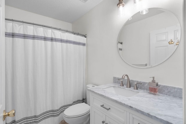 bathroom featuring toilet, vanity, and a textured ceiling