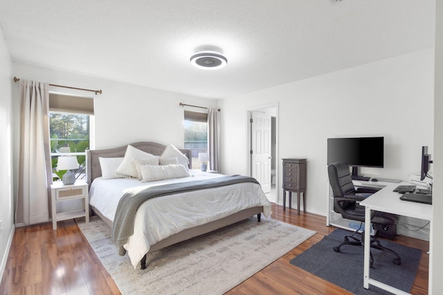 bedroom with a textured ceiling and hardwood / wood-style floors