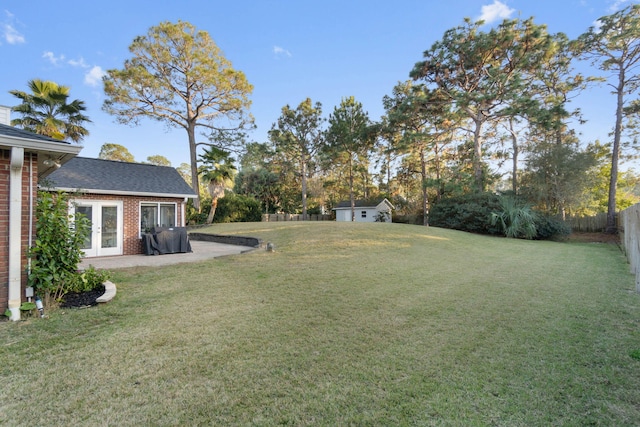 view of yard with french doors and a shed