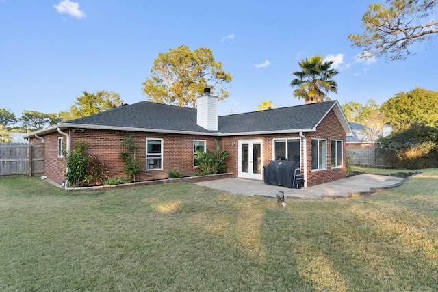 back of property featuring french doors, a patio, and a lawn