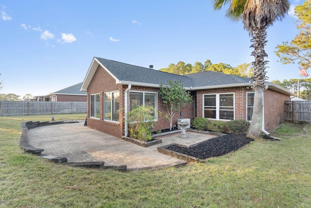 rear view of property featuring a lawn and a patio