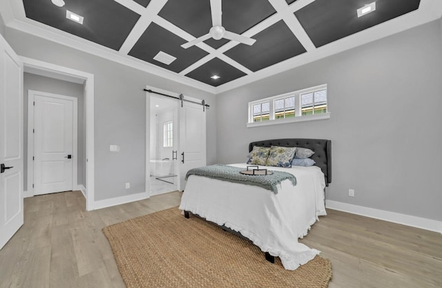 bedroom featuring ensuite bathroom, coffered ceiling, ceiling fan, a barn door, and light hardwood / wood-style flooring