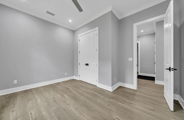 unfurnished bedroom with light wood-type flooring, a closet, ceiling fan, and crown molding