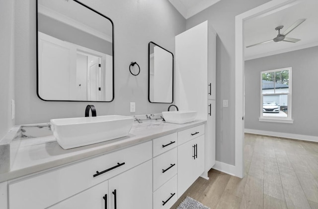 bathroom featuring wood-type flooring, vanity, ceiling fan, and ornamental molding