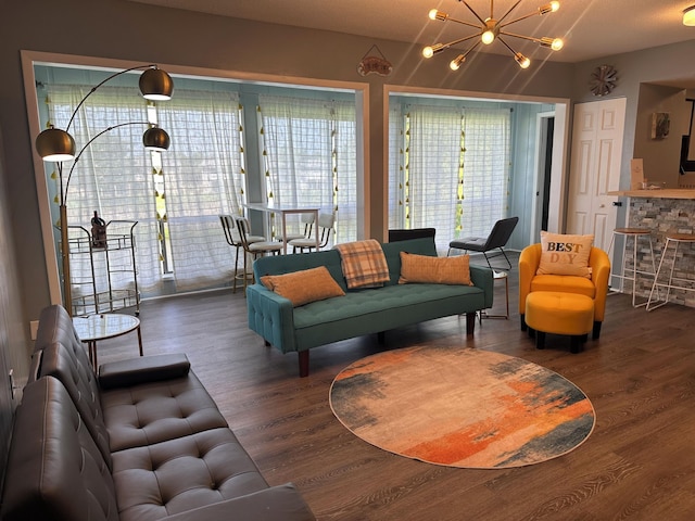 living room featuring a chandelier and dark wood-type flooring