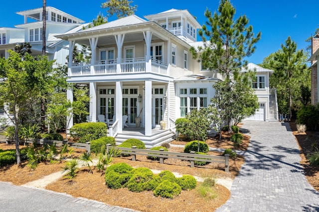 view of front facade featuring french doors, a balcony, and a garage