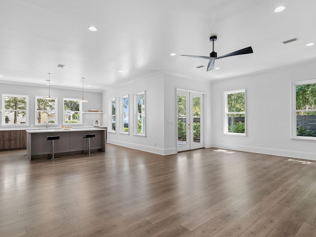 unfurnished living room with baseboards, visible vents, dark wood-type flooring, and french doors