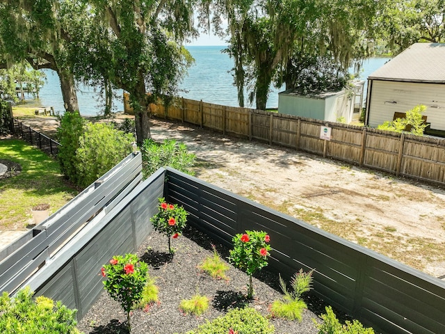 exterior space featuring a water view and a fenced backyard