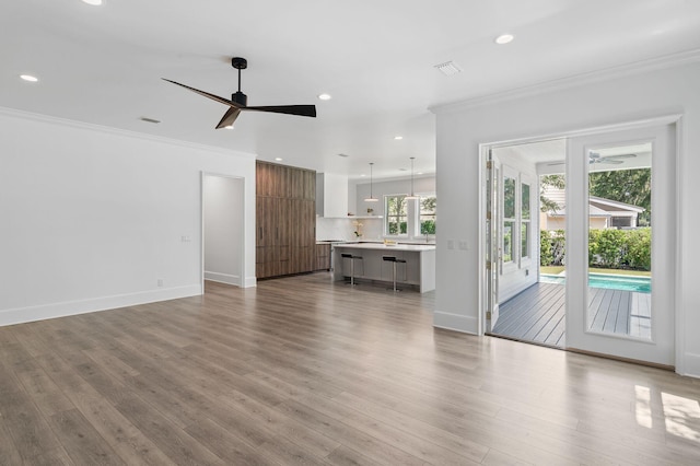 156 Beacon Point Dr, Santa Rosa Beach, FL 32459 - unfurnished living room featuring ceiling fan, crown molding, wood finished floors, recessed lighting, and baseboards