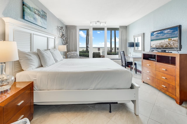 bedroom with rail lighting and light tile patterned floors