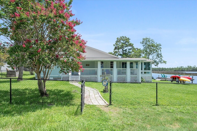 view of front of home with covered porch, a front lawn, and a water view