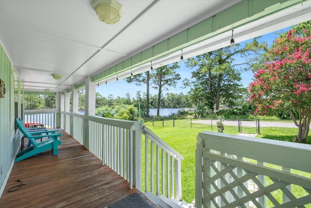 wooden deck with a lawn and a water view