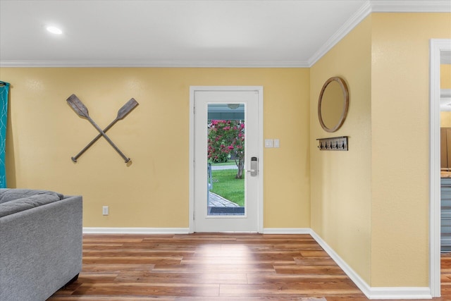 foyer entrance with ornamental molding and hardwood / wood-style floors