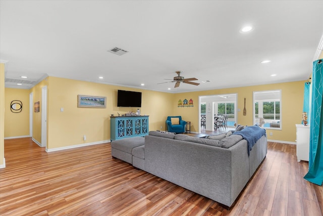 living room featuring ornamental molding, ceiling fan, and light hardwood / wood-style floors