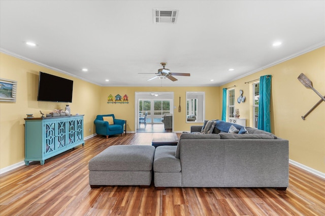 living room featuring hardwood / wood-style floors, ceiling fan, and crown molding