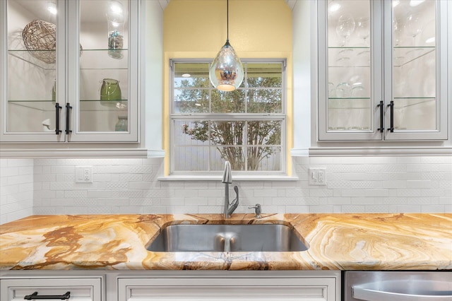 kitchen with sink, hanging light fixtures, stainless steel dishwasher, and backsplash