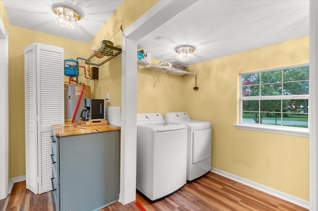 washroom featuring hardwood / wood-style floors, separate washer and dryer, and a notable chandelier