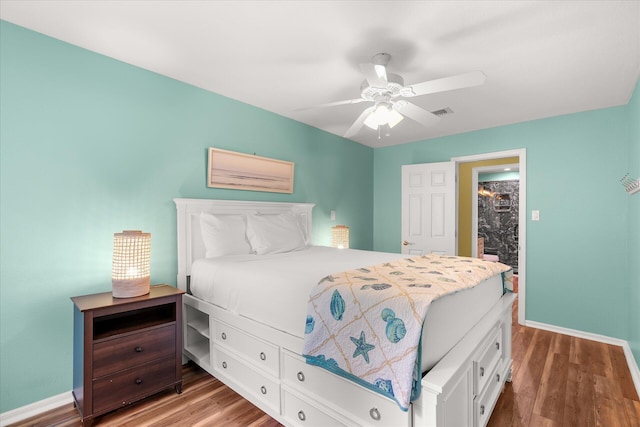 bedroom with dark hardwood / wood-style flooring, ceiling fan, and a spacious closet