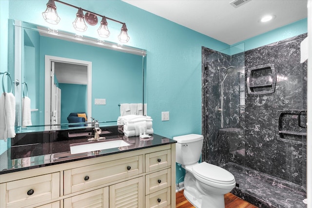 bathroom with an enclosed shower, toilet, vanity, and wood-type flooring