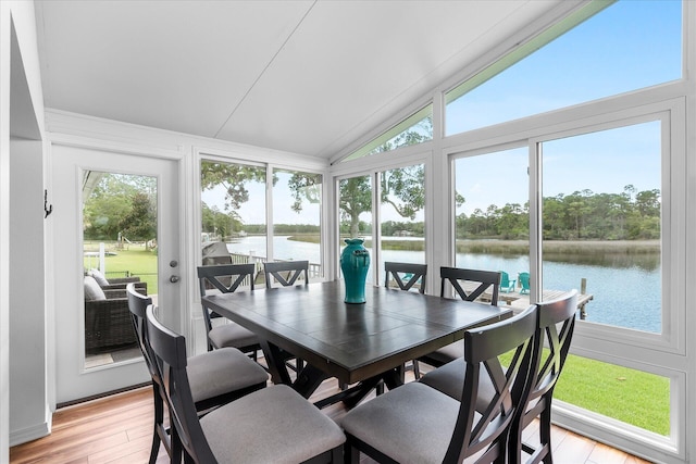 sunroom featuring vaulted ceiling and a water view