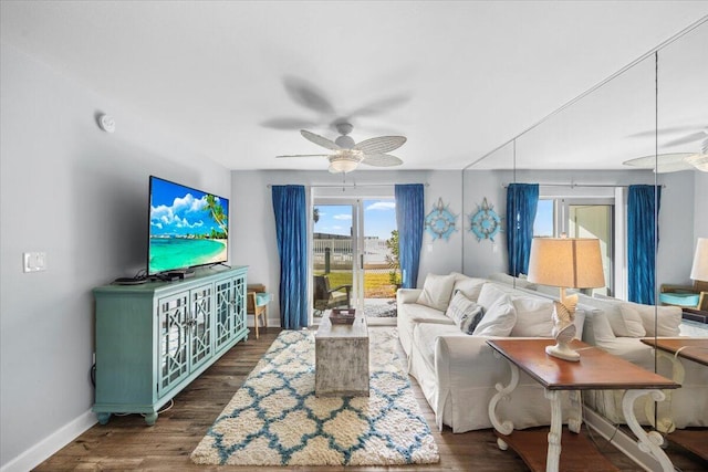 living room featuring ceiling fan and dark wood-type flooring