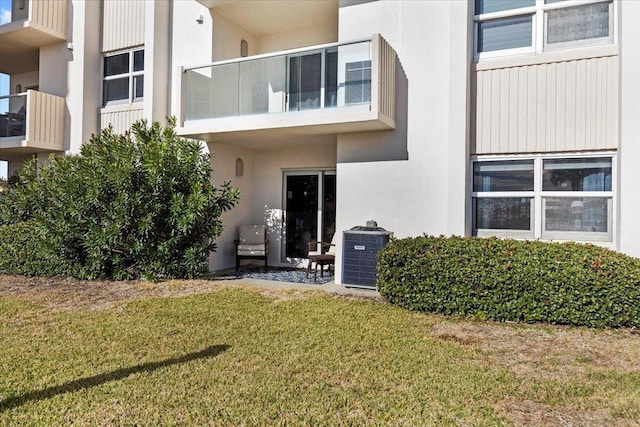 doorway to property with a yard and cooling unit