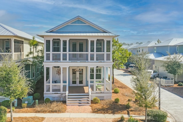 view of front of property featuring covered porch, french doors, and a balcony