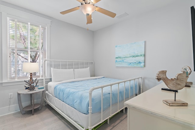 bedroom featuring a ceiling fan, baseboards, visible vents, and light wood finished floors