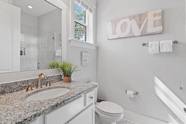 full bathroom with a stall shower, baseboards, vanity, and toilet