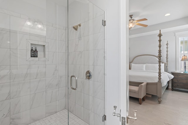 bathroom featuring a shower stall, ceiling fan, wood finished floors, and ensuite bathroom