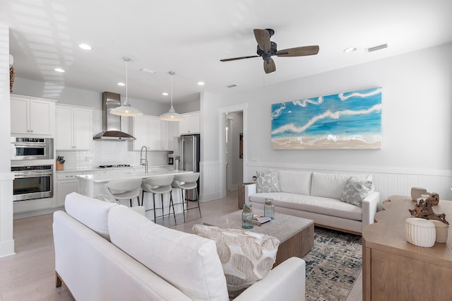 living room with recessed lighting, wainscoting, visible vents, and a ceiling fan