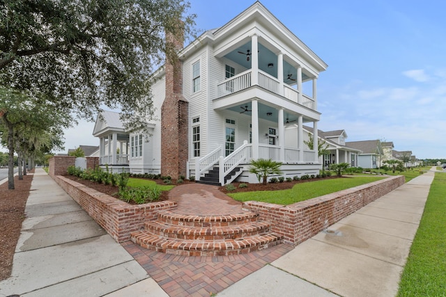 view of front of property featuring covered porch, ceiling fan, and a balcony